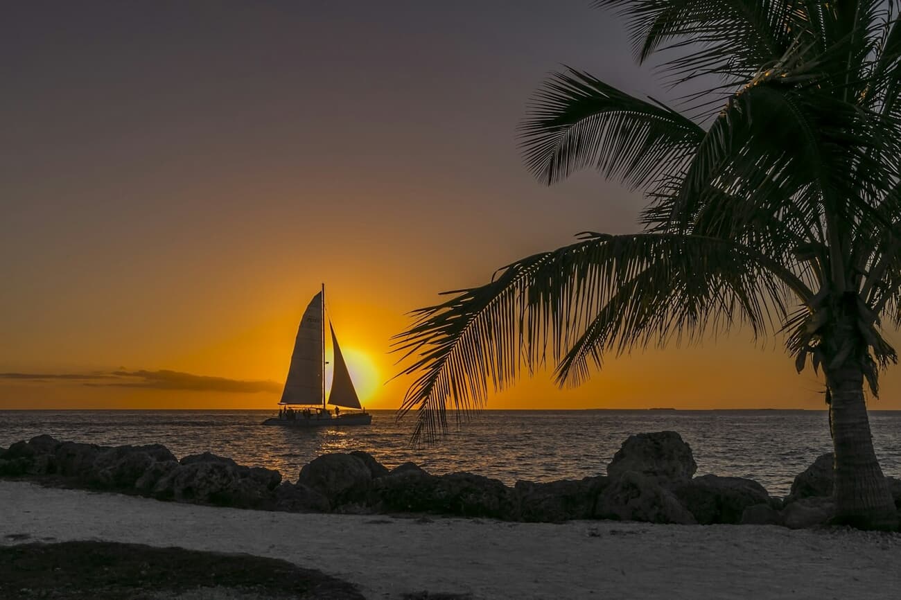 Sailboat silhouetted against a golden sunset off Key West, Florida