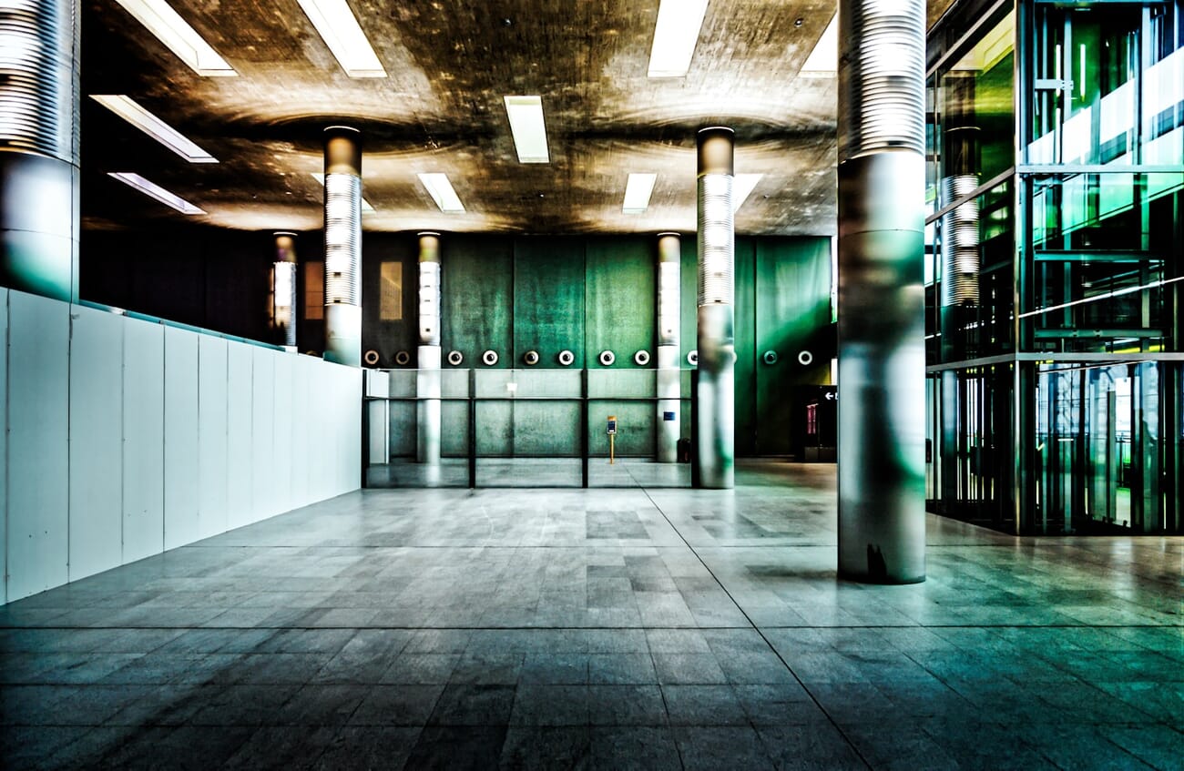 Interior concourse of Paris Charles de Gaulle Airport with concrete pillars and glass