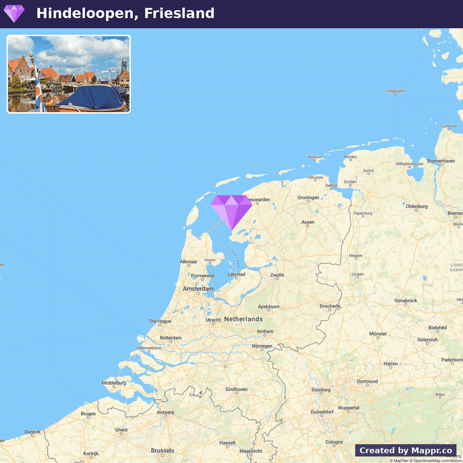 A map highlighting Hindeloopen, Friesland, in the Netherlands with an inset image showing a traditional boat and historical buildings beside a waterway under a clear blue sky.