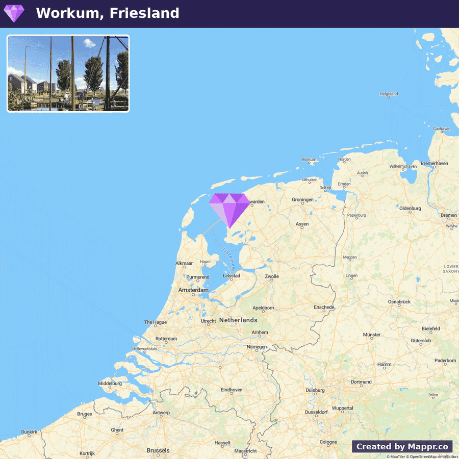 A screenshot of an interactive map highlighting the location of Workum in Friesland, Netherlands, with an inset photograph on the top left corner showing a scenic view of boats moored in a canal with greenery and houses in the background.