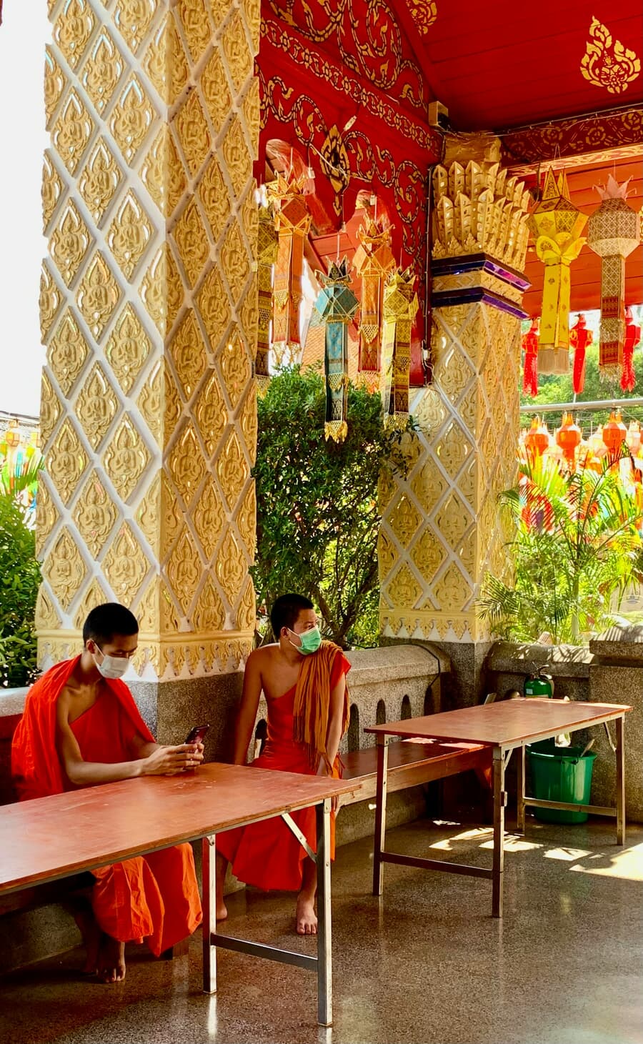 Monks in saffron robes beneath the gilded pillars of Wat Phra Singh, one of Chiang Mai's most revered temples.