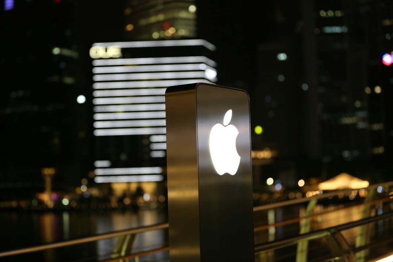 The Apple Store dome floating on Marina Bay in Singapore at night, illuminated with the city skyline in the background