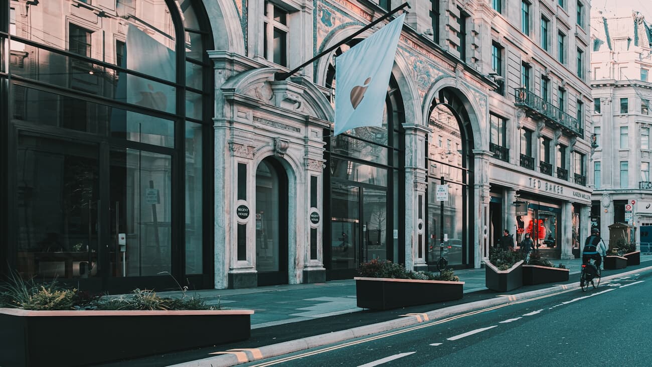The Grade II-listed Regent Street Apple Store facade in London at sunrise, with an Apple pennant flag above the entrance