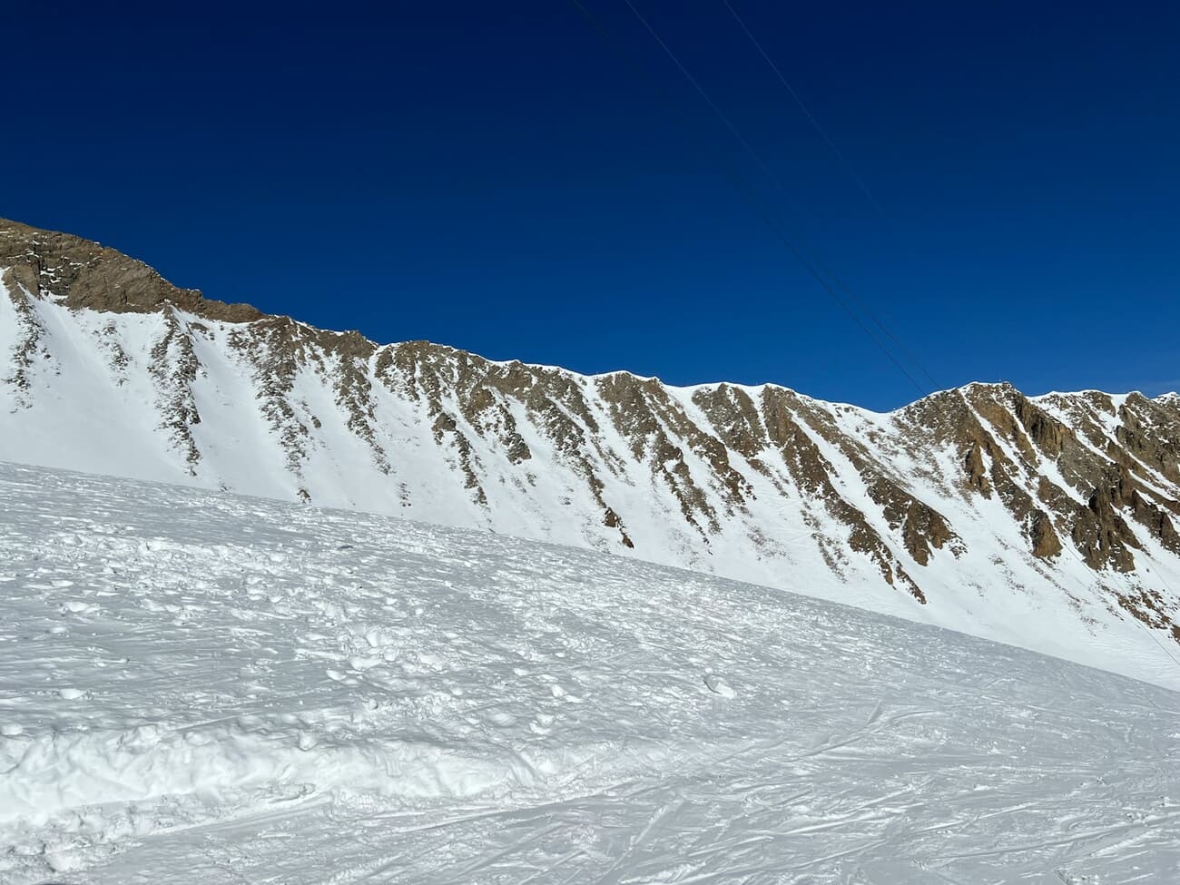 Groomed runs cut across the high alpine terrain at Big Sky, Montana, under a deep winter sky