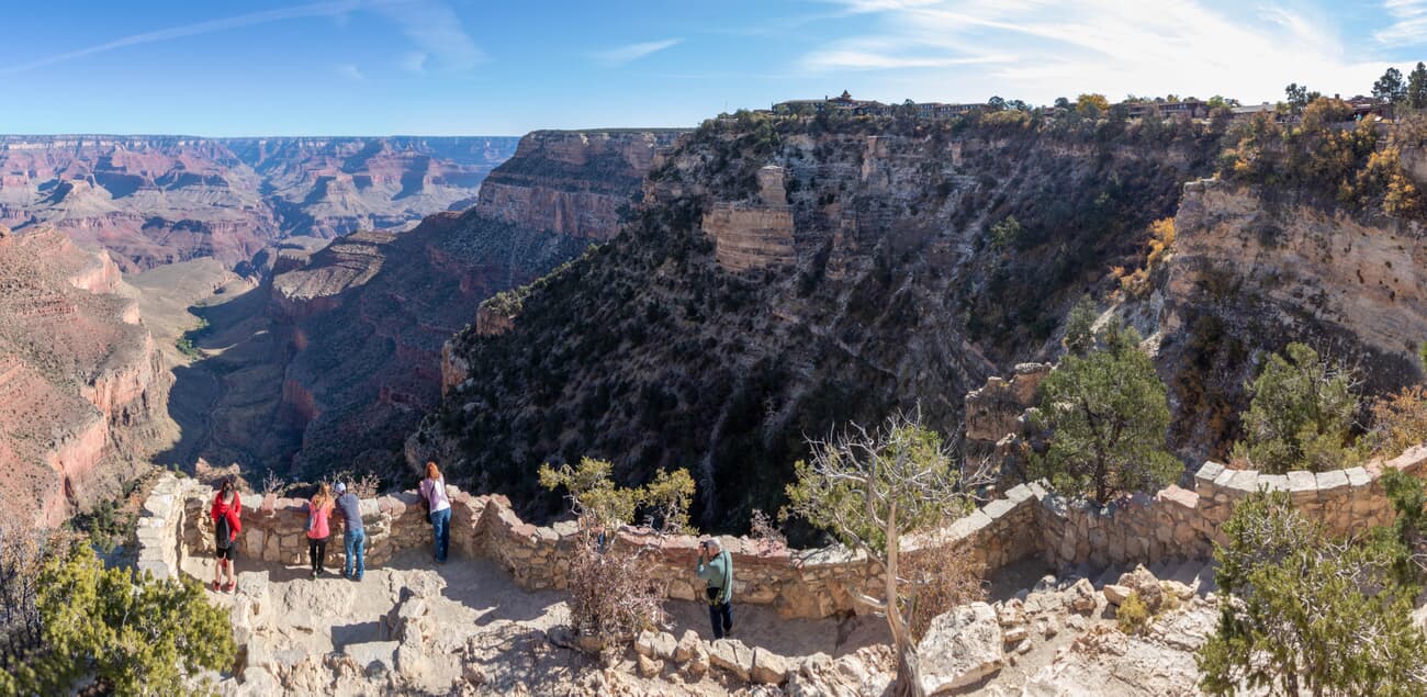 Visitors take in the sweep of the canyon from a South Rim overlook in Grand Canyon National Park, Arizona