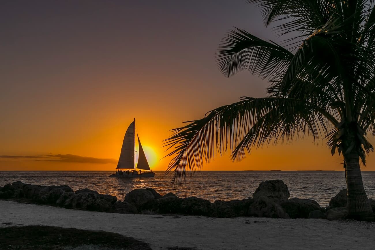 A sailboat crosses the sunset off Key West, Florida, where the evening light show is a nightly ritual
