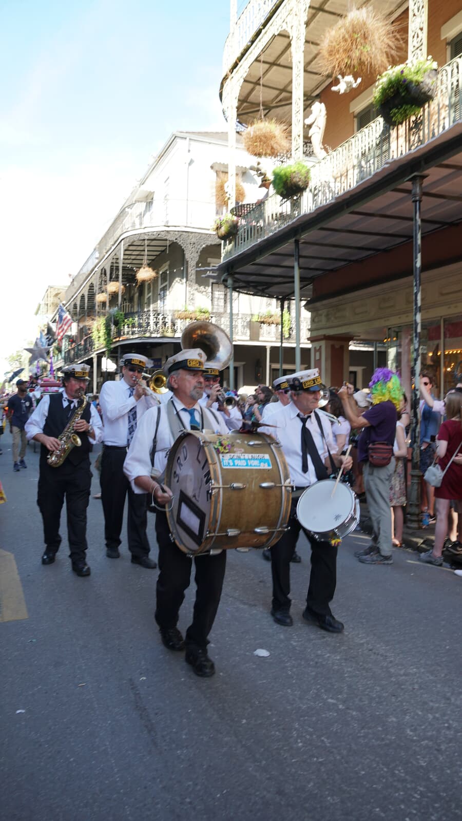 A brass band parades beneath the iron balconies of the French Quarter in New Orleans