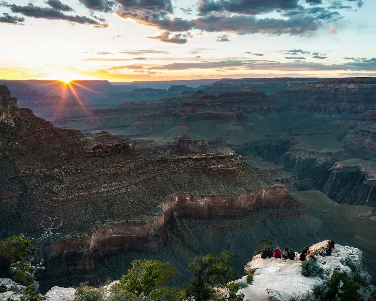 The sun breaks over the layered rock walls of the Grand Canyon in Arizona