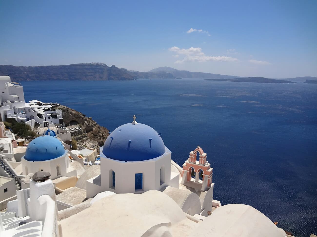 Blue-domed churches overlook the caldera from the cliff villages of Santorini, Greece