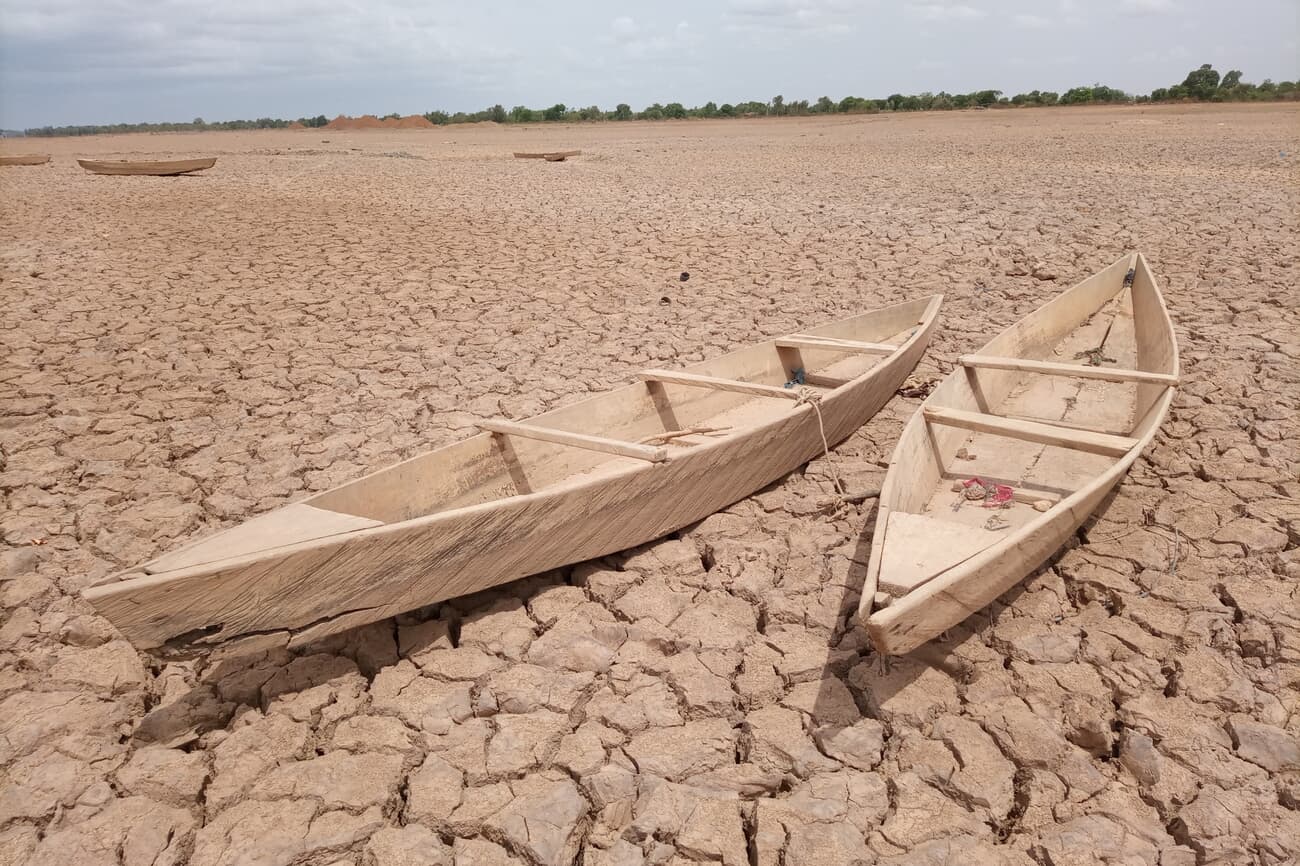 Dry, cracked earth with abandoned boats in the Sahel