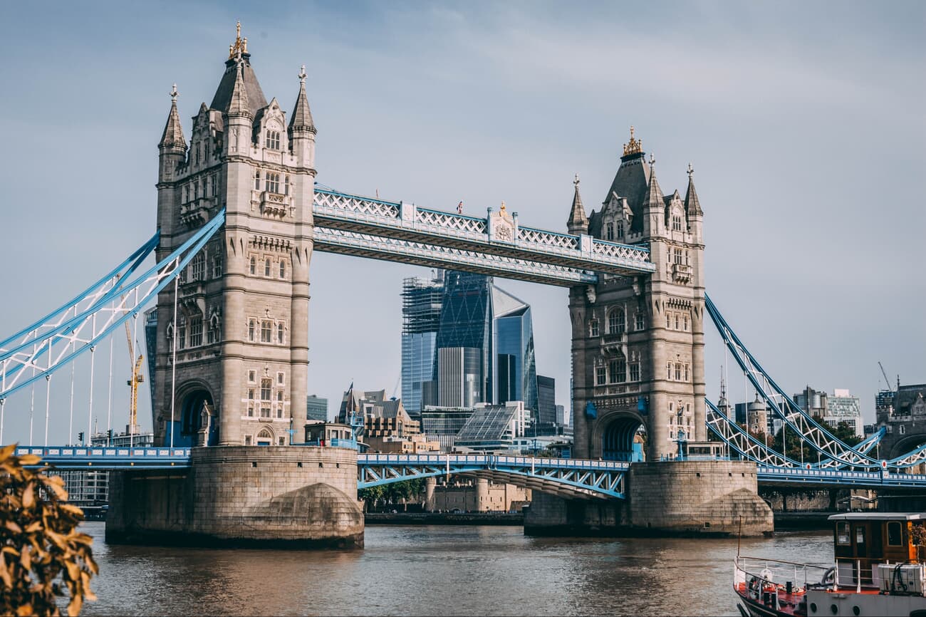 A photo of London's Tower Bridge over the Thames, with the city skyline behind it.