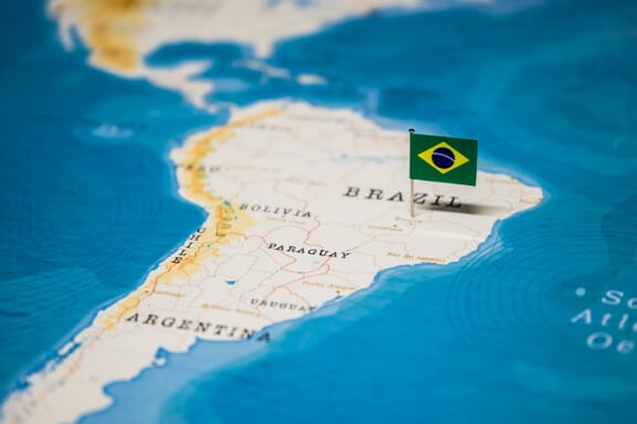 Flag pin pointing out the location of Brazil on the South America map