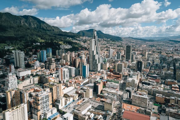 The skyline of Bogotá, Colombia can be seen in front of green hills.