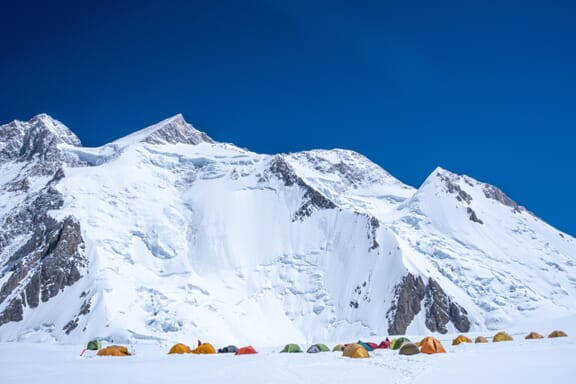 Colorful tents sit on the snow at Camp I of Gasherbrum II, one of the highest mountains in the world.