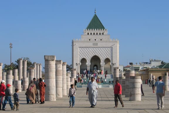 A crowd of people walk around the entrance to the Mausoleum of Mohammed V. A crowd of people walk around the entrance to the Mausoleum of Mohammed V.