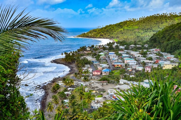 A small town sits back from the shore on an island in Saint Vincent and the Grenadines.