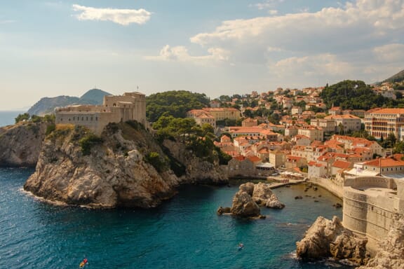 Red-roofed buildings sit near the water in Dubrovnik, Croatia.
