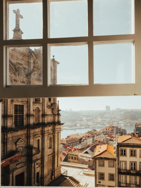 Part of the skyline of Porto, Portugal can be seen through an open window. Part of the skyline of Porto, Portugal can be seen through an open window.