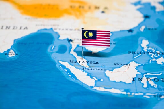 Malaysia pointed out on the map by a flag pin.
