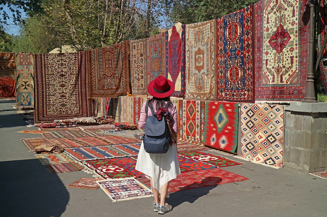Female Traveler Observing the Handmade Carpets at Vernissage