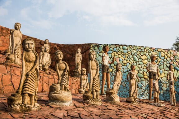 Several stone statues stand in the sun at Chandigarh’s Rock Garden.