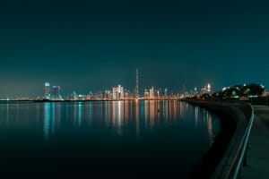 Dubai skyline at night with the Burj Khalifa towering above lit waterfront — the United Arab Emirates leads the world in AI adoption in Q1 2026 at 70.1% of its working-age population.